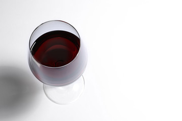 Glass of red wine on white background, above view. Space for text