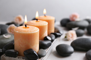 Beautiful composition with candles and spa stones on table. Space for text