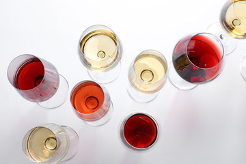 Different glasses with wine on white background, top view