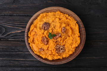 Bowl with mashed sweet potatoes on wooden background, top view
