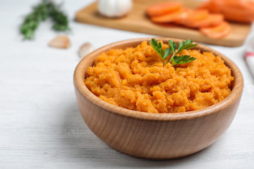Bowl with mashed sweet potatoes on wooden table