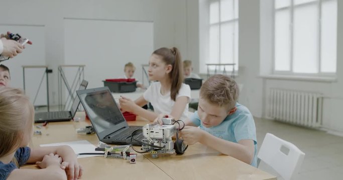 Curious kids working on a functional programable robot during robotics class at school. 4K UHD 60 FPS SLOW MOTION