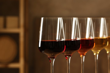 Glasses of different wines in cellar, closeup. Expensive collection