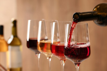 Pouring wine from bottle into glass on blurred background, closeup - Powered by Adobe