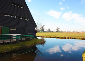 spring trip to Zaanse Schans. Placid channels, tranquil rivers flow between the hills. The Dutch windmills stand as a traditional tourist landmark after centuries