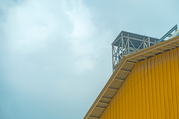 Factory of yellow wall building on blue sky
