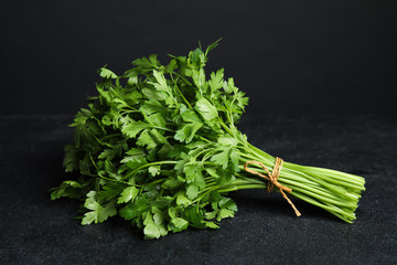 Bunch of fresh green parsley on dark table