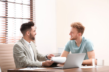 Insurance agent consulting young man in office