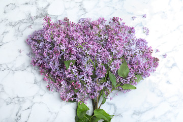 Blossoming lilac on marble table, top view. Spring flowers