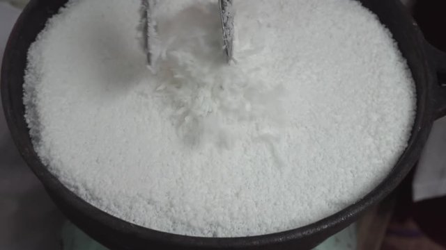 Tapioca starch. Adding grated coconut to Beiju (or Biju) recipe on black iron skillet at brazilian open-air marketplace, a free fair farmer Market on the street.