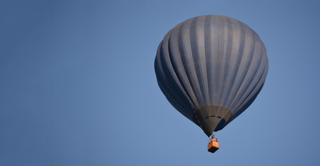 Dark blue balloon in the sky. Aerostat. People in the basket. Fun. Summer entertainment. Romantic adventures.