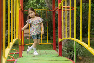 Children's fashion. Little girl in fashionable things is posing on the playground. Amazing little kid of three or four years old is posing as fashion model.