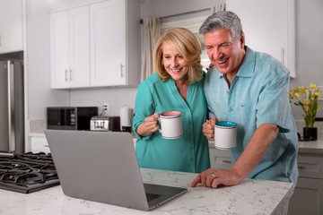 Obraz premium Newly retired couple home with coffee and computer, possibly video conference call chat with friends