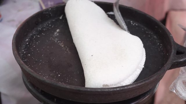 Tapioca from cassava plant (also known as manioc or yuca). wrapping up condensed milk with grated coconut in Beiju (or Biju) at brazilian open-air marketplace, a free fair farmer Market on the street.