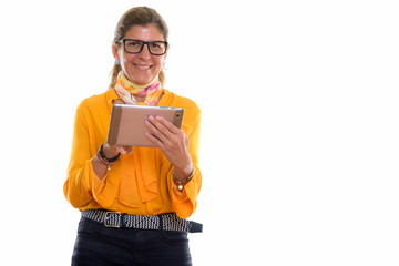 Studio shot of mature happy businesswoman smiling and using digi