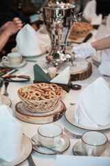 Traditional russian baked goods: pies and pretzels, samovar, honey, jam on the served table