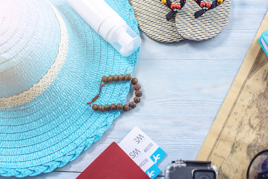 Travel holiday supplies: hat, sunglasses, flip flops, passport on blue background. Going on a trip to the sea. Flat lay