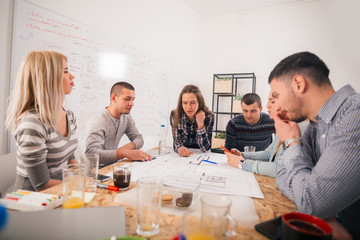 Negotiating the architectural plan, discussing the advantages and the disadvantages of the plan between the architects and the buyers.