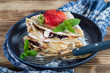 Polish pancakes with jam, cheese and strawberries.