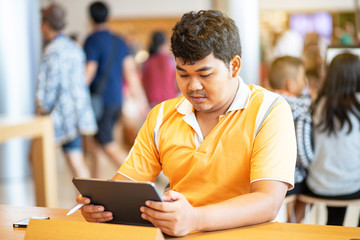 Man holding stylus pen and looking at his tablet
