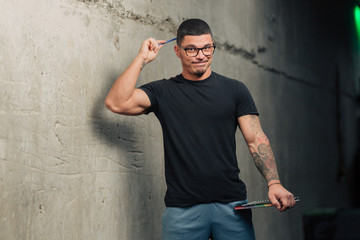 Young fitness trainer in the gym with clipboard and glasses pointing
