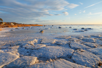 Sunset over frozen coast of the Baltic sea. Calm winter moment.
