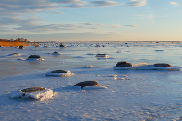 Sunset over frozen coast of the Baltic sea. Calm winter moment.