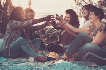 Group of happy cheerful adult caucasian women celebrate with wine together during the sunset at the...