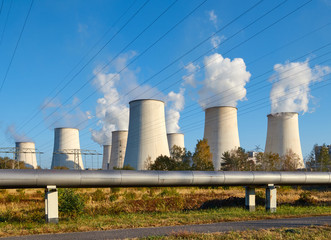Power plant smoking chimney at sunset, environmental pollution concept.