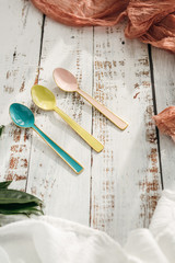 Three Colorful Spoons on White Wooden Background