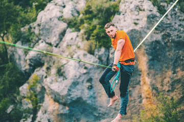 A man sits on a stretched sling.