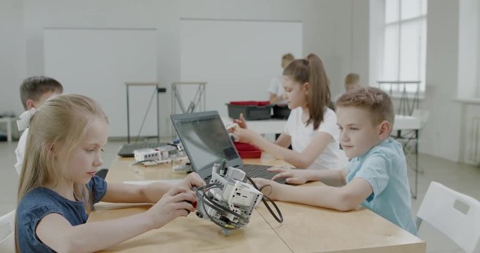 Curious kids working on a functional programable robot during robotics class at school. 4K UHD 60 FPS SLOW MOTION