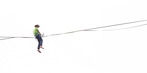 A man sits on a stretched sling on a white background.