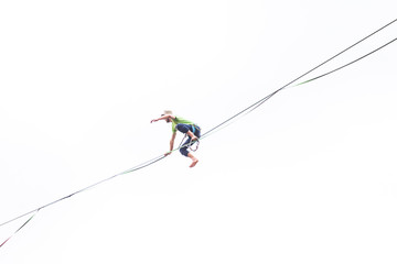 A man sits on a stretched sling on a white background.