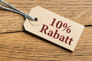 Hangtag mit Aufschrift "10% Rabatt" auf Holzhintergrund