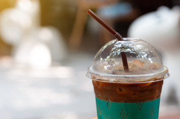 Ice coffee, cappuccino with ice in plastic glass and straw.  Refreshment beverage with coffee and milk.