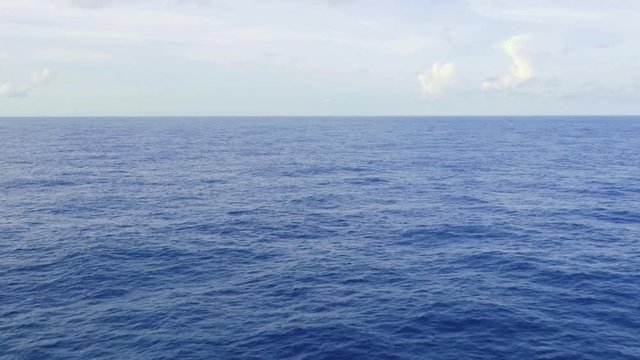 ship view of the open endless blue ocean, calm sea, with the sky above the horizon