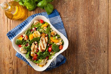 Traditional Greek salad with grilled Halloumi cheese with basil. Top view. Flat lay.