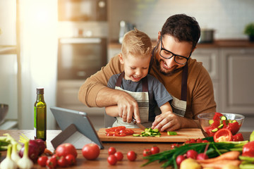 happy family father with son preparing vegetable salad . - Powered by Adobe