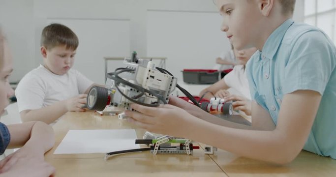 Curious kids working on a functional programable robot during robotics class at school. 4K UHD 60 FPS SLOW MOTION