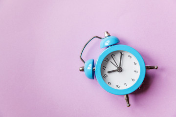Ringing twin bell vintage classic alarm clock Isolated on purple violet pastel colourful...