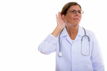 Studio shot of mature beautiful woman doctor listening while thi