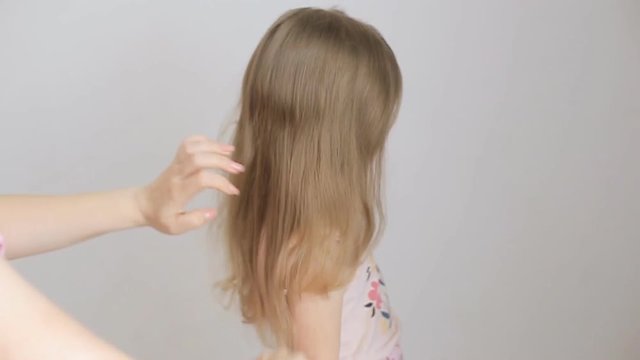 mom combs blonde hair for little girl early in the morning