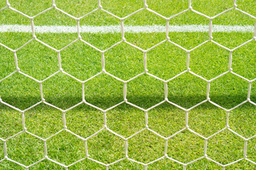 Close up detail of a soccer net against green grass