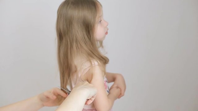 mom combs blonde hair for little girl early in the morning