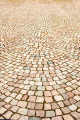 A fragment of the sidewalk, lined with colored granite stone in the town square.  Texture, background.