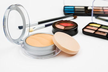 Set of makeup cosmetic: shadows, brushes, lipstick on a white background, closeup