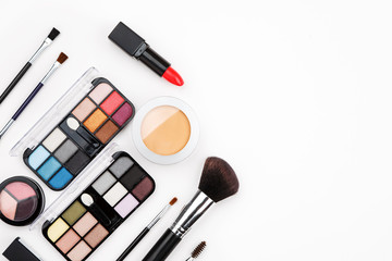 Set of makeup cosmetic: shadows, brushes, lipstick on a white background, top view, text space