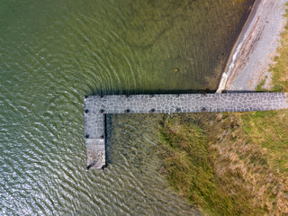 Aerial view of beautiful stone pier in Furnas lagoon, Azores islands. Drone landscape view with lines and textures. Top view of  romantic scenary, tourist attraction of Portugal.