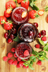 assortment of jams, seasonal berries, cherry, mint and fruits in glass jar